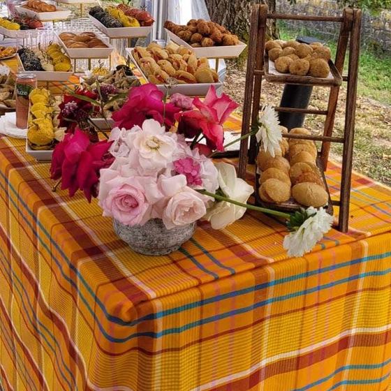 Un bouquet de roses posé sur la nappe madras d'un buffet.
