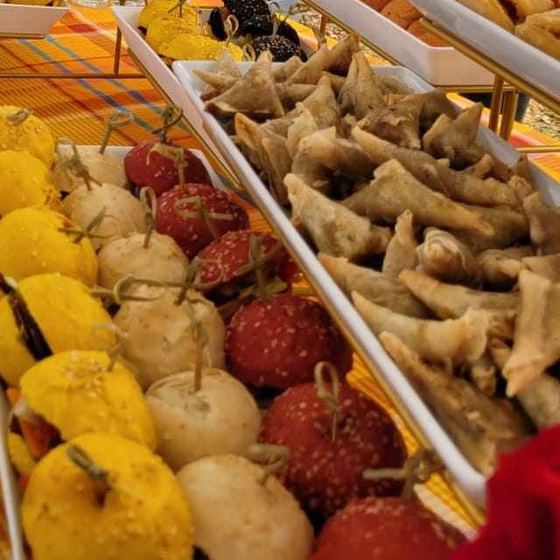 Des plateaux de mini-burgers colorés et de samoussas.